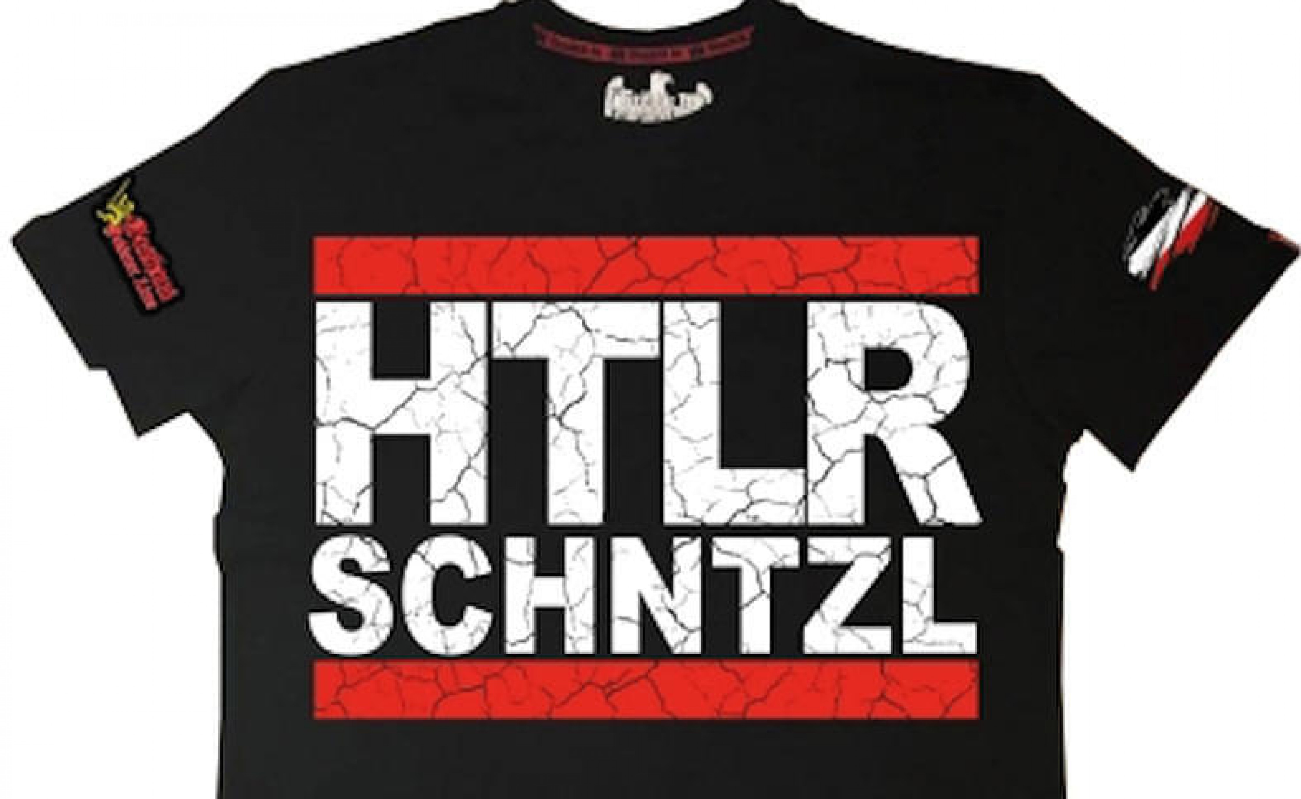 Schwarzes T-Shirt mit großen Buchstaben "HTLR SCHNTZL" und roten, rissigen Balken. Schriftzüge auf den Ärmeln und ein Adler am Kragen.