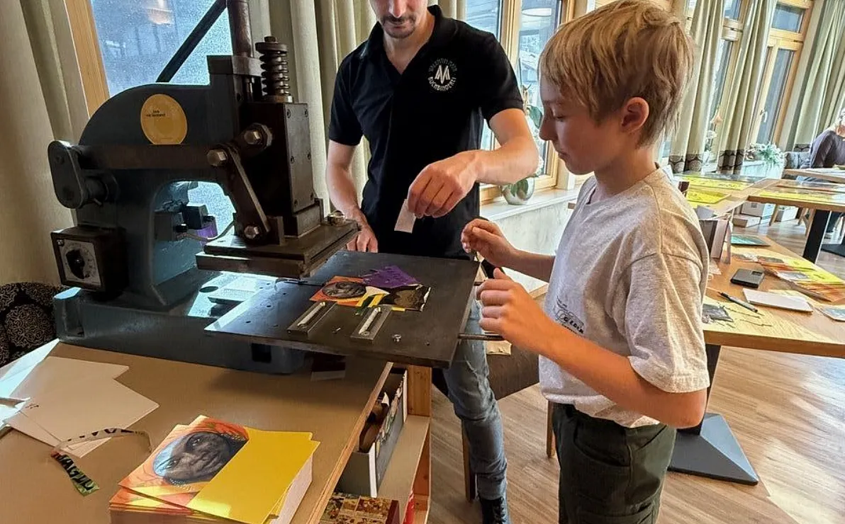Valentin Mayr mit Sohn beim Prägedruck der  Kunstfieber Souvenir Karte
