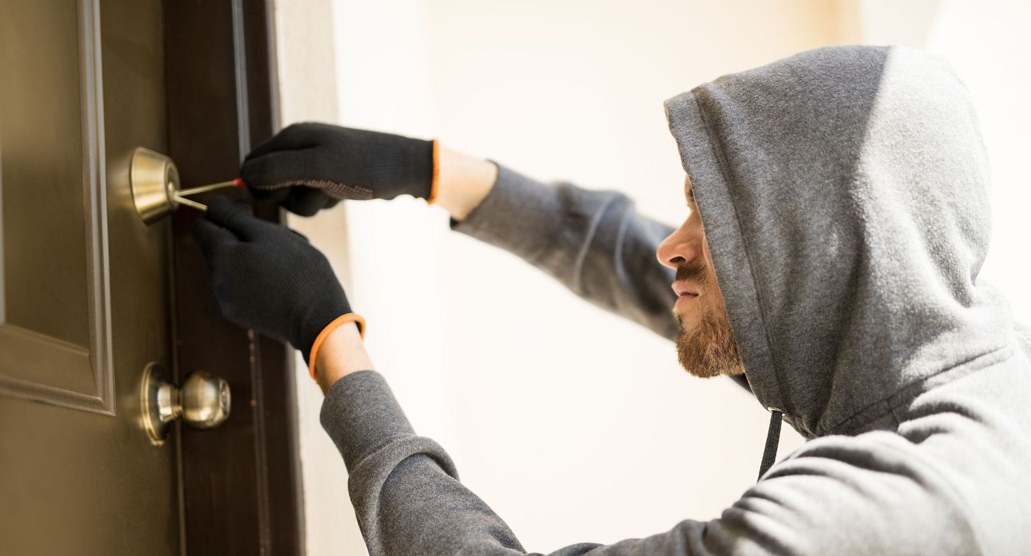 Einbrecher_profile-view-man-with-hoodie-trying-pick-lock-house-forcing-his-entry
