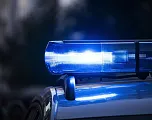 Nahaufnahme eines blauen Polizeilichts, das in der Dunkelheit blinkt. Der Hintergrund ist verschwommen, was das Hauptaugenmerk auf das Licht lenkt.